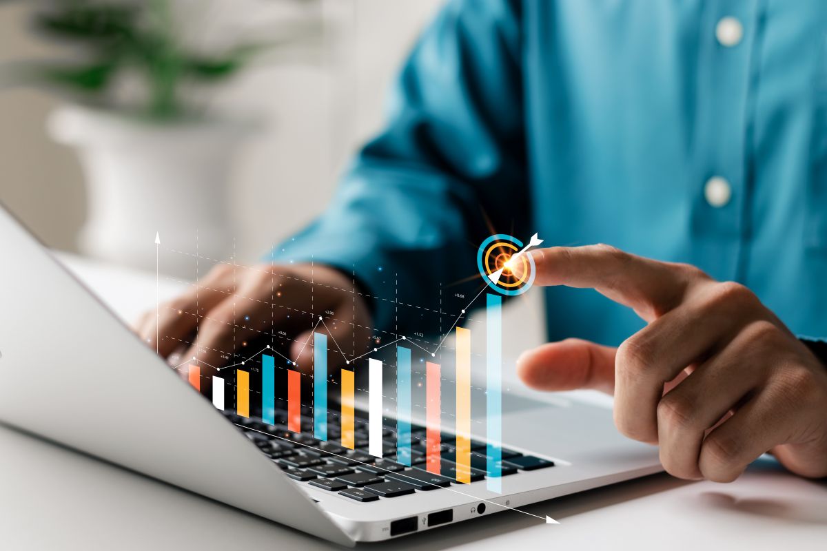 A person taps a target icon atop a rising graph