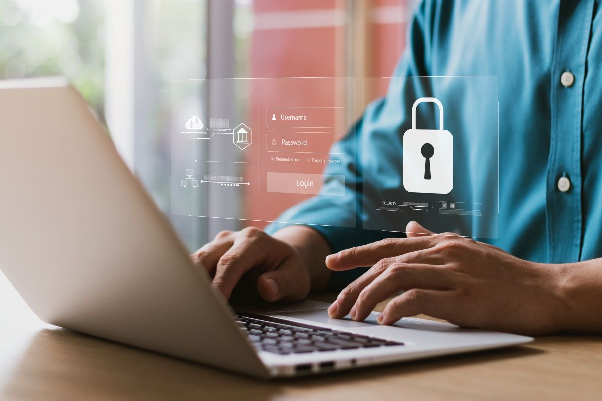 A person types on a laptop overlayed with a graphic for a username and password