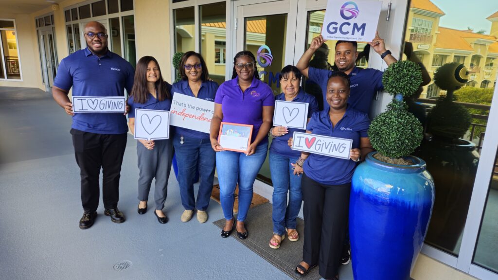 A group of GCM employees holding signs supporting their volunteering initiatives. 