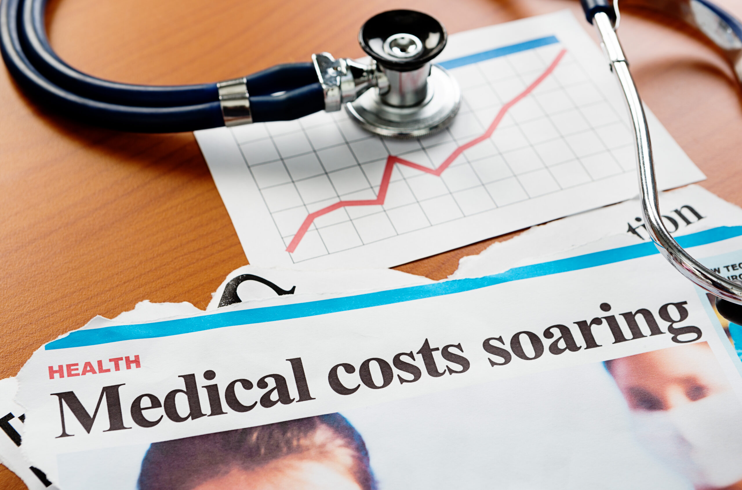 A stethoscope, rising chart, and health article claiming healthcare costs are rising